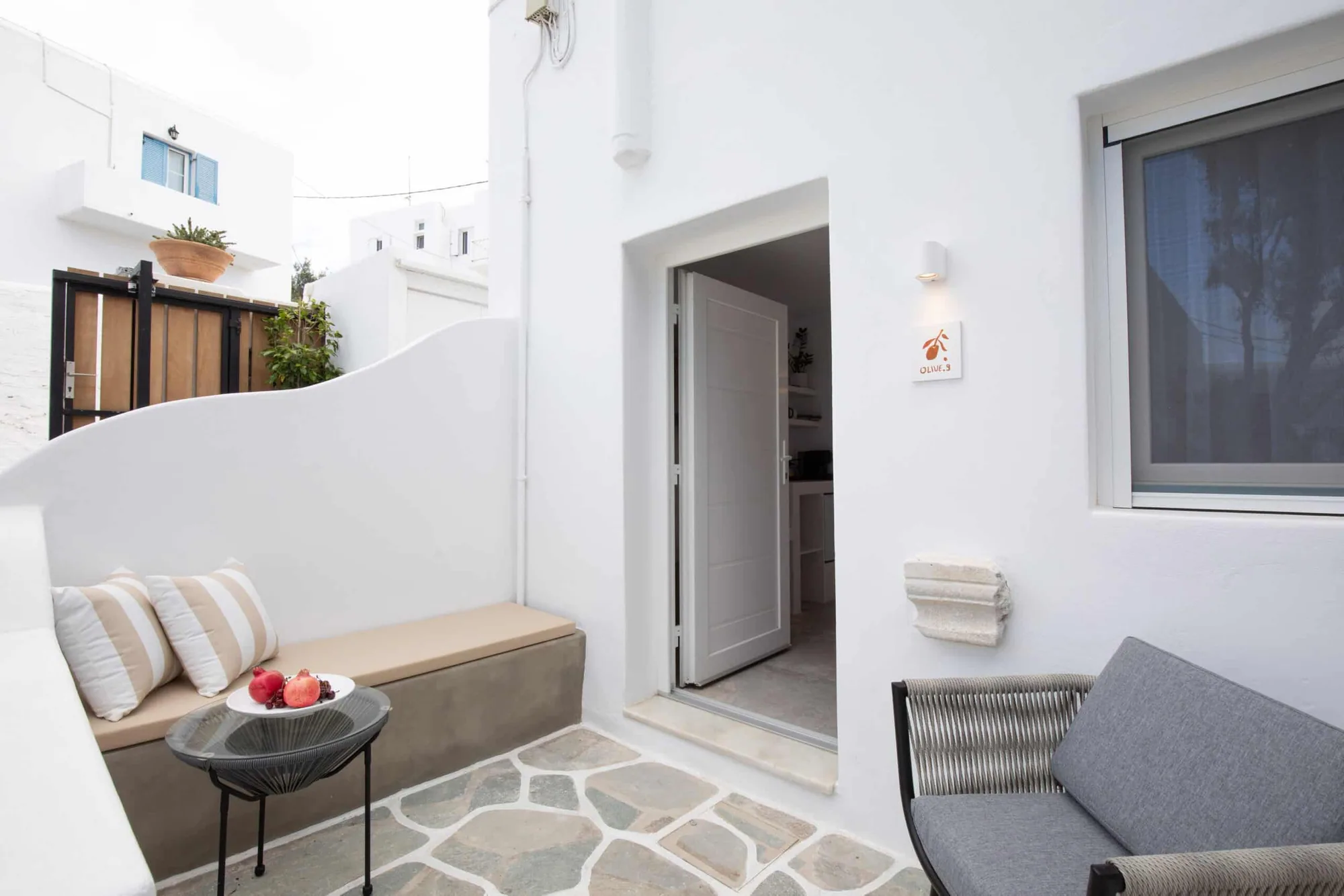 Private patio with cushioned bench outside the entrance